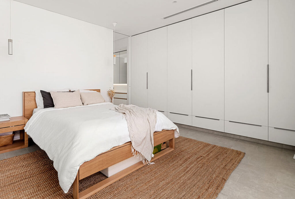 Floor to ceiling white wardrobes with minimal style handles